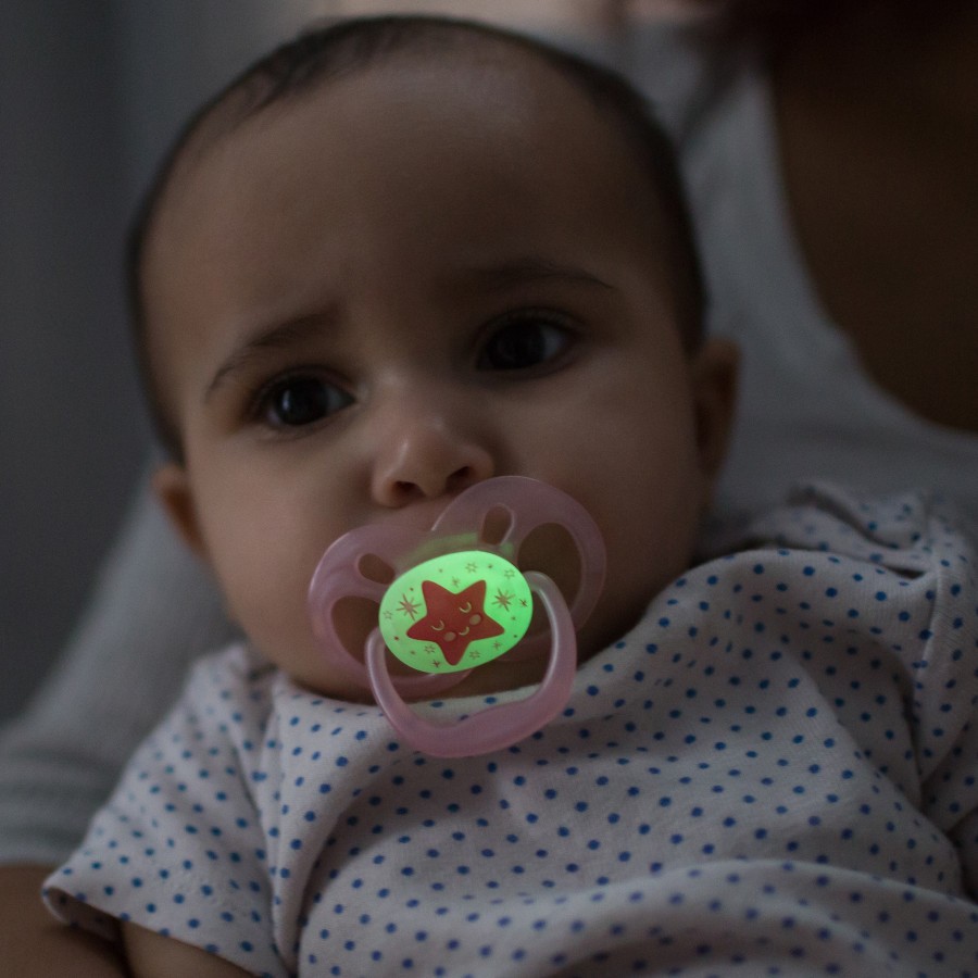 Lifestyle_Advantage_Glow_in_the_Dark_Stage_2_O16A8387 Baby in mother's arms in dark room with glow-in-the-dark pacifier in mouth
